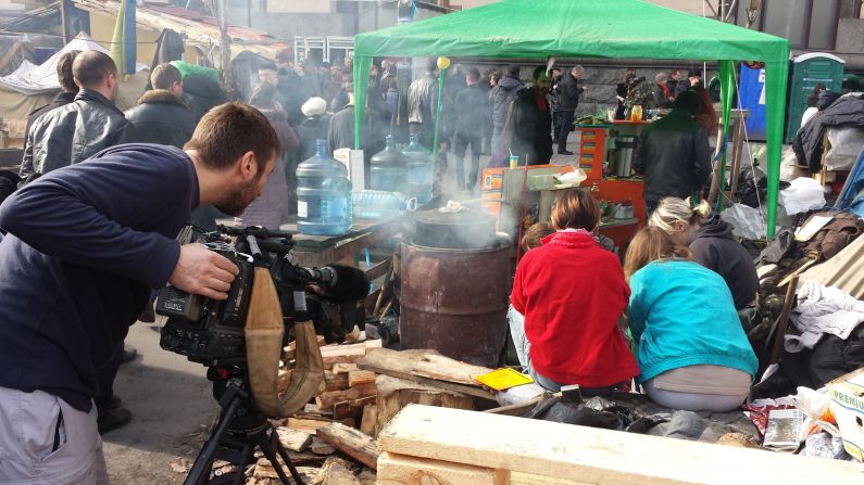 KIEV, UKRAINE:  CNN cameraman Scott McWhinnie films volunteers peeling vegetables, preparing meals for protesters still living in tents in Maidan, also known as Independence Square, on March 9.  Photo by CNN's Michael Holmes.  Follow Michael on Instagram at <a href="https://trans.hiragana.jp/ruby/http://instagram.com/holmescnn" target="_blank" target="_blank">instagram.com/holmescnn</a>.