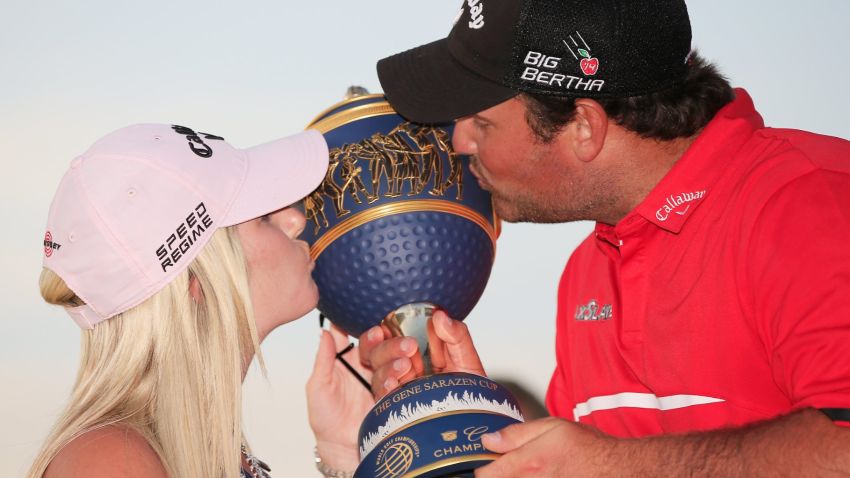 Patrick Reed celebrates his victory in Florida with his wife Justine as they kiss the Gene Sarazen trophy.