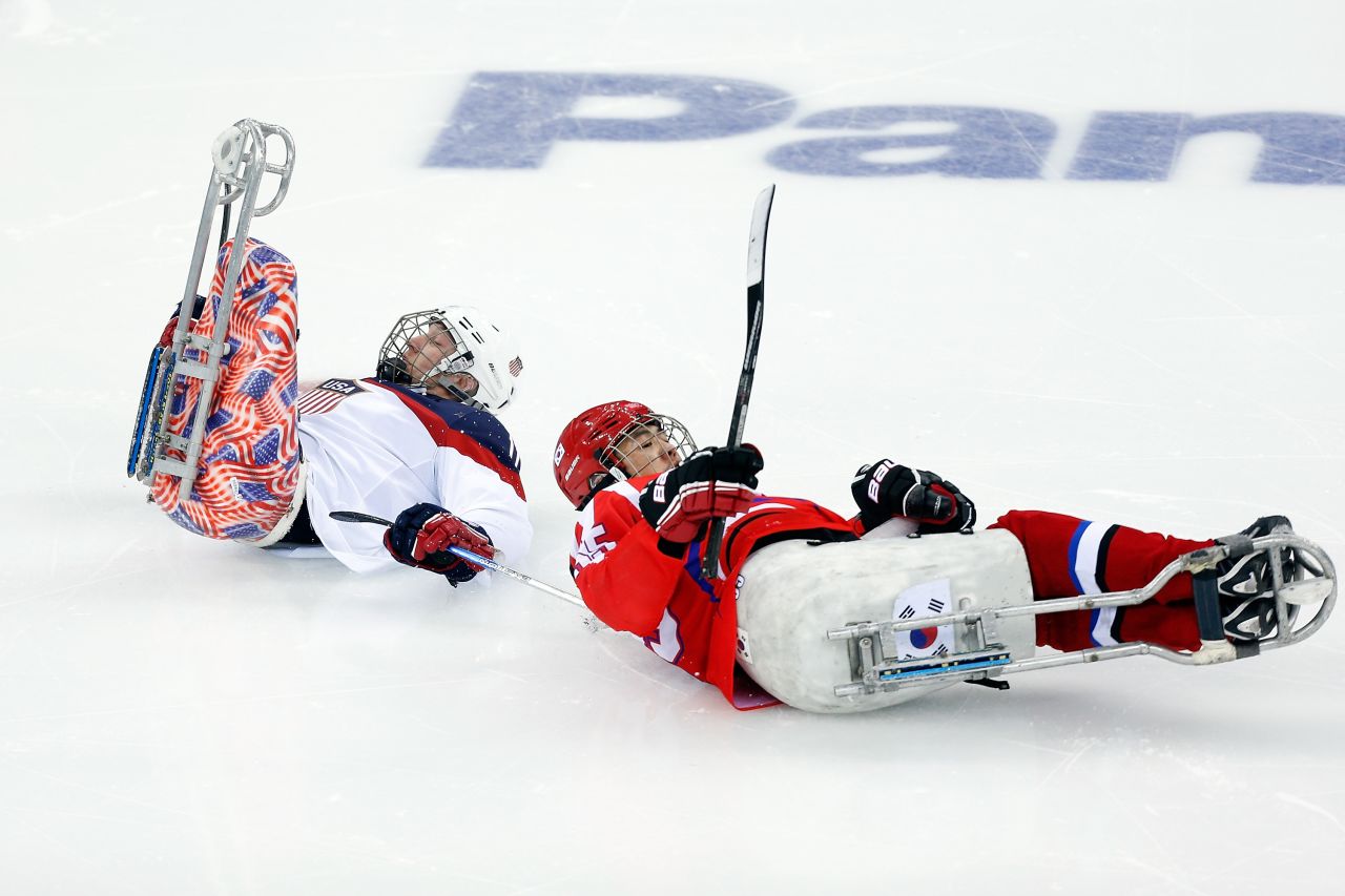Tyler Carron of the United States, left, collides with Jong Ho-jang of South Korea during a ice sledge hockey game on March 9. 
