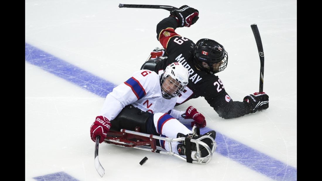 Graeme Murray of Canada and Emil Kirstistuen of Norway vie for the puck during an ice sledge hockey game on Sunday, March 9.