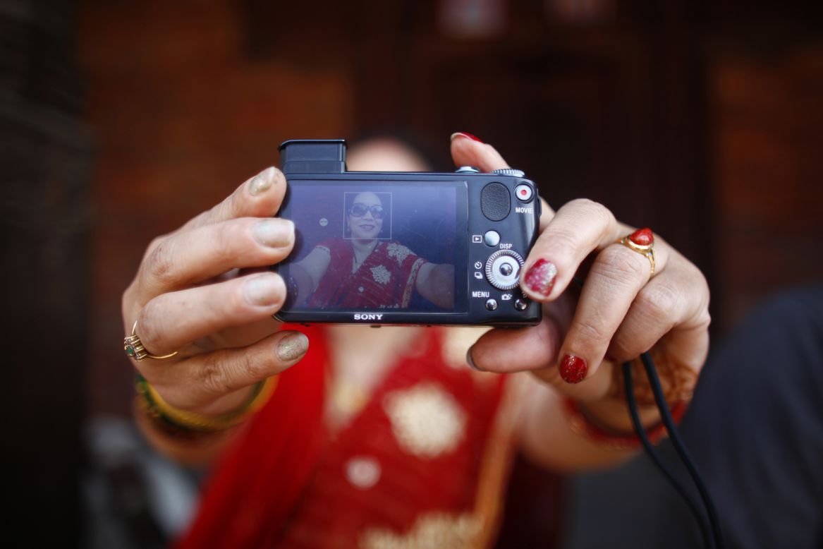MARCH 10 - KATHMANDU, NEPAL: A Nepalese woman takes a selfie outside a temple. People around the world marked International Women's Day on Saturday, celebrating women's achievements and campaigning for gender equality. Joining them was <a href="http://edition.cnn.com/2014/03/08/living/cnnwomen-tweetchat-as-it-happened/index.html">CNN's Leading Women team which hosted a global discussion on equality</a>.