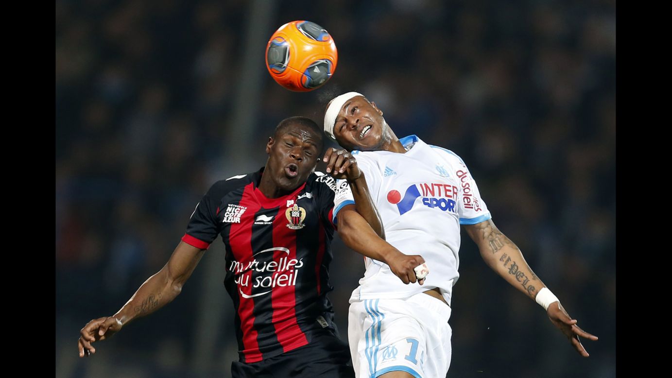 Marseille's Andre Ayew, right, collides with Nice's Romain Genevois as he heads the ball during a Ligue 1 soccer match Friday, March 7, in Marseille, France.