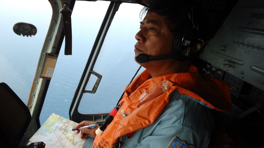 This picture taken aboard a Vietnamese Air Force Russian-made MI-171 helicopter shows a crew member in the cockpit during a search flight some 200 km over the southern Vietnamese waters off Vietnam's island Phu Quoc on March 11, 2014 as part of continued efforts aimed at finding traces of the missing Malaysia Airlines MH370.