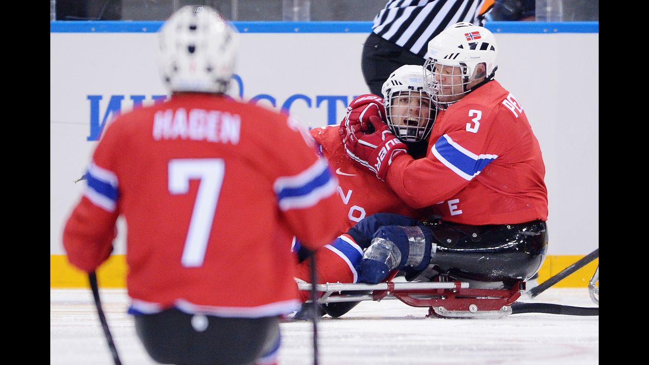 Audun Bakke of Norway, center, celebrates with teammates after scoring Norway's second goal March 11 during their sledge hockey game against Sweden.