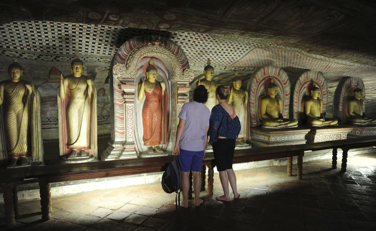 Buddhist statues line the walls in Dambulla's cave temple, a UNESCO World Heritage Site that dates to the 1st century BC.