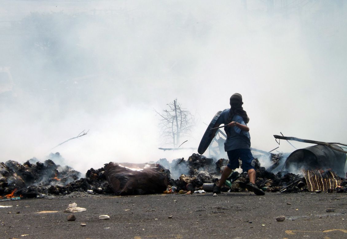 Un manifestante arroja rocas desde una barricada en San Cristóbal el 11 de marzo. 
