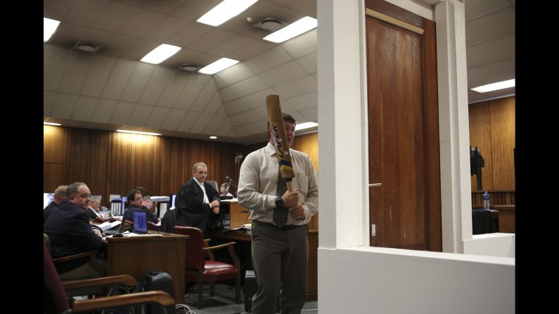 A police officer takes part in a court reconstruction March 12. A police forensic expert said Pistorius was on the stumps of his amputated legs when he knocked down a locked toilet door with a cricket bat to reach his shot girlfriend. That counters the track star's assertion he was wearing his prosthetic legs at the time. Defense attorney Barry Roux countered by suggesting that even with his prosthetic legs on, Pistorius would not be swinging a bat at the same height as an able-bodied person.
