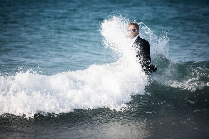 Waves crash against Thomson, bedecked in only a water-resistant designer suit, which is worn for the entire stunt, as he returns to shore.
