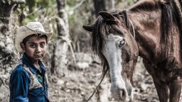 A boy and his blind pony in the countryside near Chimaltenango, Guatemala, February 2013. The boy's father was the local rag and bone man and with the boy riding the pony, they helped to pull his cart