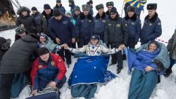 In this handout provided by NASA, Expedition 38 Flight Engineer Sergey Ryazanskiy of the Russian Federal Space Agency, Roscosmos, left, Commander Oleg Kotov of Roscosmos, center, and, Flight Engineer Mike Hopkins of NASA, sit in chairs outside the Soyuz TMA-10M capsule shortly after they landed in a remote area on March 11 near the town of Zhezkazgan, Kazakhstan.