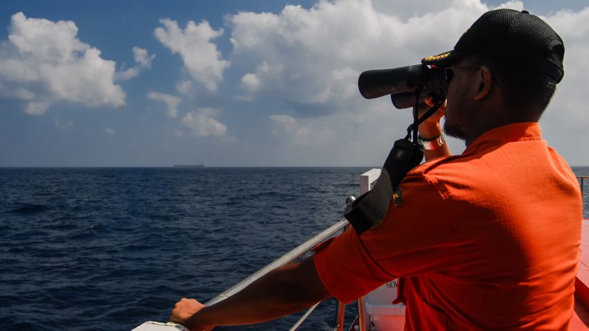 An Indonesian National Search and Rescue Agency personnel scans the seas aboard a boat on patrol in the Malacca Strait off Aceh province located in the area of northern Sumatra island on March 12, 2014 during the continued search for the missing Malaysia Airlines flight MH370