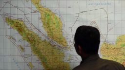 A member of the Indonesian Air Force at Medan city military base inspects the Indonesian military search operation for the missing Malaysian Airlines flight MH370 on March 12, 2014 in the area of Malacca Strait, a sea passageway between Indonesia (seen left of the map) and Malaysia (seen top left of the map). Malaysia faced a storm of criticism on March 12 over contradictions and information gaps in the hunt for a missing airliner with 239 people on board, as the search zone dramatically veered far from the intended flight path.       AFP PHOTO / ATAR        (Photo credit should read ATAR/AFP/Getty Images)