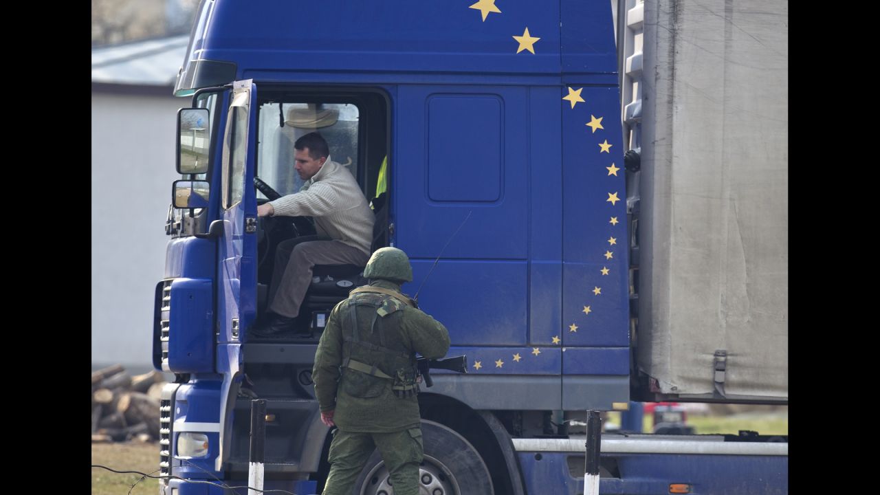 A pro-Russian soldier speaks to a truck driver outside the Ukrainian infantry base in Perevalne on Wednesday, March 12.