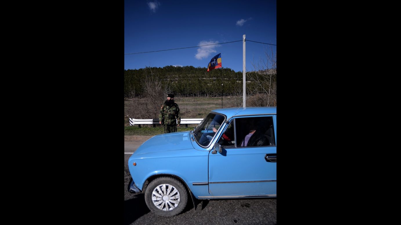 An armed Cossack stands guard at a checkpoint on the road from Simferopol to Sevastopol on March 13.