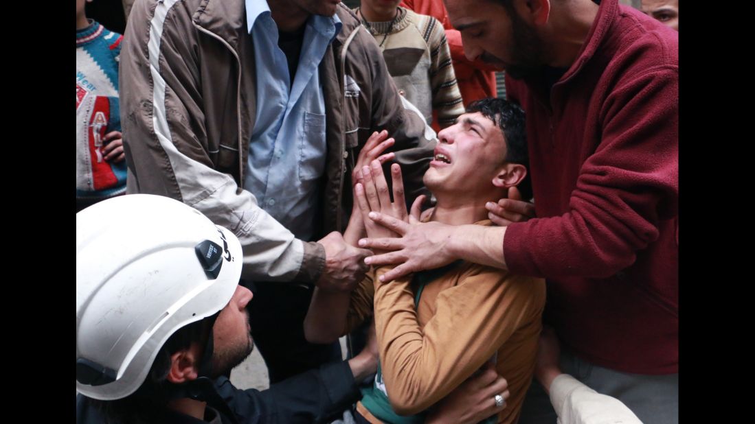 People attempt to comfort a man in Aleppo after a reported airstrike by government forces on Sunday, March 9. 