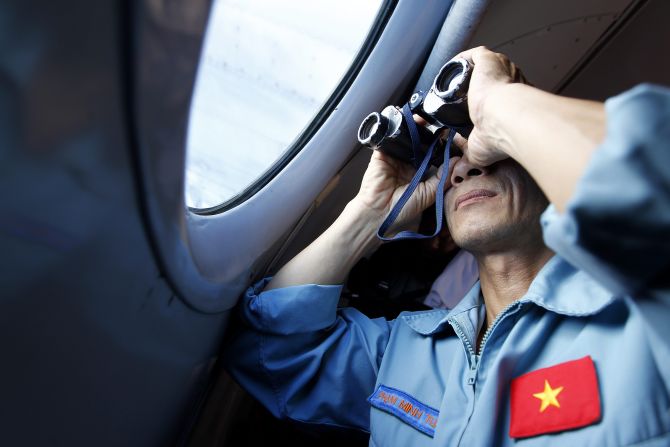 A Vietnamese military official looks out of a plane Thursday, March 13, while <a href="http://www.cnn.com/2014/03/07/asia/gallery/malaysia-airliner/index.html">searching for a Malaysia Airlines jet</a> that went missing days earlier. Malaysia Airlines Flight 370 disappeared Saturday, March 8, somewhere over Southeast Asia. There were 239 people on board: 227 passengers and 12 crew members.