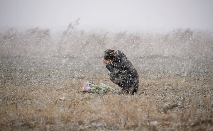 A woman in Rikuzentakata, Japan, prays in falling snow Tuesday, March 11, on the third anniversary of the devastating Tohoku earthquake and tsunami.