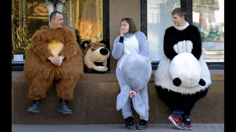 Three Ukrainians take a break in front of a luxury fashion shop near Independence Square in Kiev, Ukraine, on Tuesday, March 11.