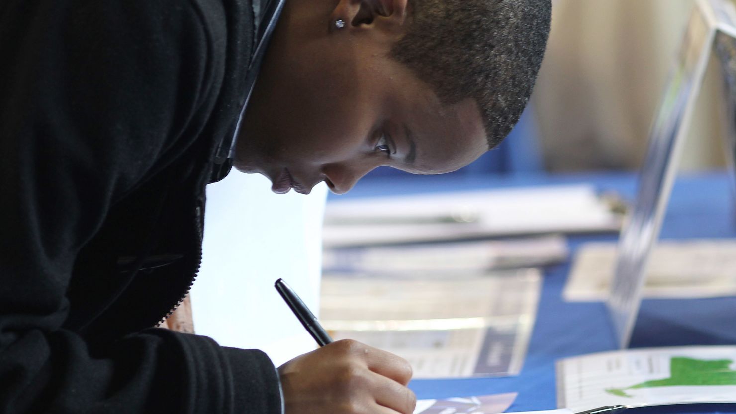 A teenager fills out an application at a job fair in Queens, New York. 