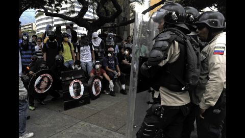 Anti-government activists, left, face riot police in Caracas on Thursday, March 13.
