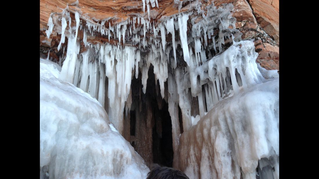 Stalactites ranging in size from a few inches to several feet dangle from a cave.