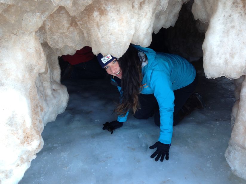 Nina Kolar of St. Paul, Minnesota, crawls out of an ice cave. Kolar drove to the ice caves with two friends hoping to see the caves before warmer temperatures begin melting them.