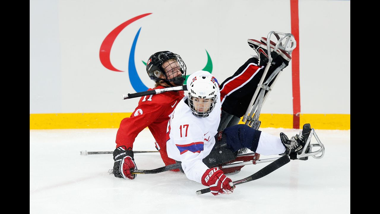 Loyd-Remi Pallander Solberg of Norway, left, collides with Adam Dixon of Canada during the ice sledge hockey bronze medal match at Shayba Arena during the Paralympic Winter Games on Saturday, March 15, in Sochi, Russia.