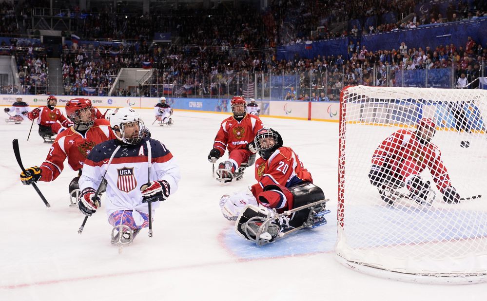 Joshua Sweeney of the United States scores the game-winning goal past Vladimir Kamantcev of Russia during the ice sledge hockey gold medal game between the United States and Russia on March 15.