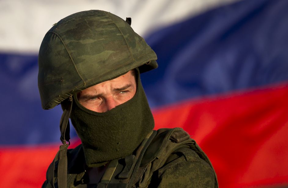 A pro-Russian soldier, with the Russian flag behind him, mans a machine gun outside an Ukrainian military base in Perevalne on Saturday, March 15.
