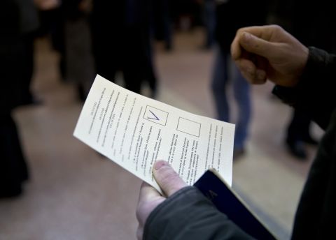 A man holds a ballot after casting a vote in favor of separation from Ukraine in the Crimean referendum in Simferopol, Ukraine, on March 16.