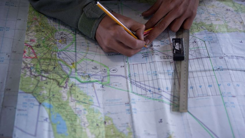 Caption: Royal Malaysian Air Force Navigator captain, Izam Fareq Hassan marks locations on a map onboard a Malaysian Air Force CN235 aircraft during a search and rescue (SAR) operation to find the missing Malaysia Airlines flight MH370 plane over the Strait of Malacca on March 14, 2014. Malaysia confirmed on March 14 that the search for a missing Malaysia Airlines plane had been expanded into the Indian Ocean, but declined to comment on US reports that the jet had flown for hours after going missing. AFP PHOTO / MOHD RASFANMOHD RASFAN/AFP/Getty Images
