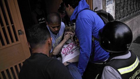 An injured demonstrator receives help during clashes in Caracas on March 15.
