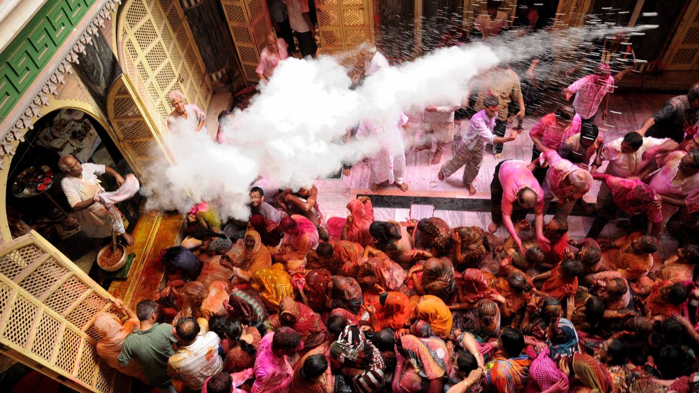 A priest throws colored powder over devotees as they celebrate Holi at the Radha Krishna temple in Kolkata on March 17.