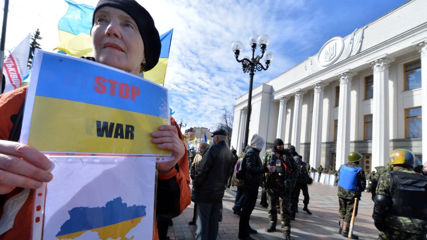 A woman holds a placard with an Ukraine's map reading 'Stop War' in front of the parliament in Kiev on March 17, 2014. Ukrainian troops will remain in Crimea, the country's defence minister said that day even as media reported the separatist peninsula planned to disband Ukrainian units there. The day before Crimeans voted overwhelmingly to join former political master Russia as tensions soared in the east of the splintered ex-Soviet nation amid the worst East-West crisis since the Cold War. AFP PHOTO/ SERGEI SUPINSKY (Photo credit should read SERGEI SUPINSKY/AFP/Getty Images)