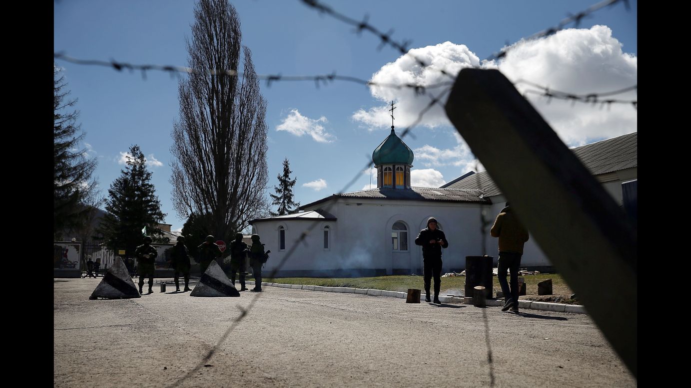 Armed soldiers stand guard outside a Ukrainian military base in Perevalne on March 17.
