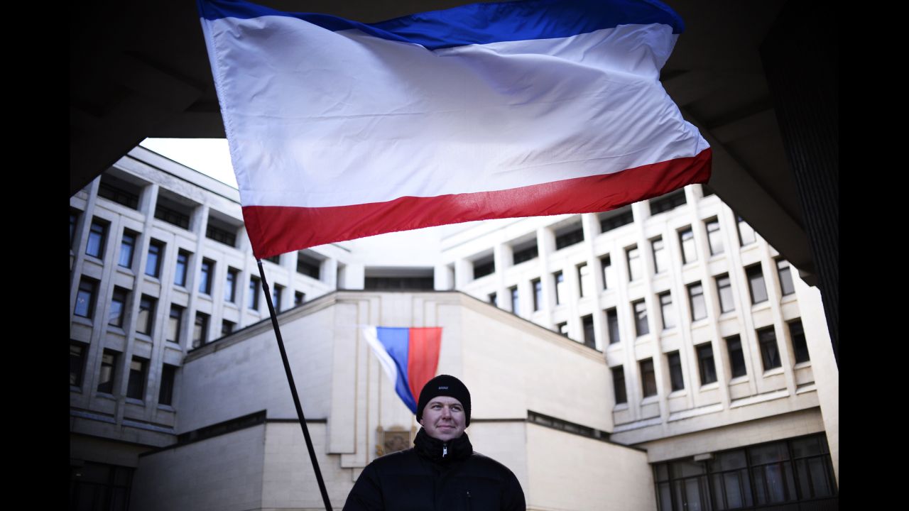 A man holds a Crimean flag as he stands in front of the Crimean parliament building in Simferopol on March 17.
