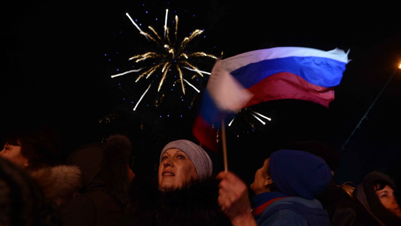 Crimeans holding Russian flags celebrate in front of the parliament building in Simferopol on Sunday, March 16.
