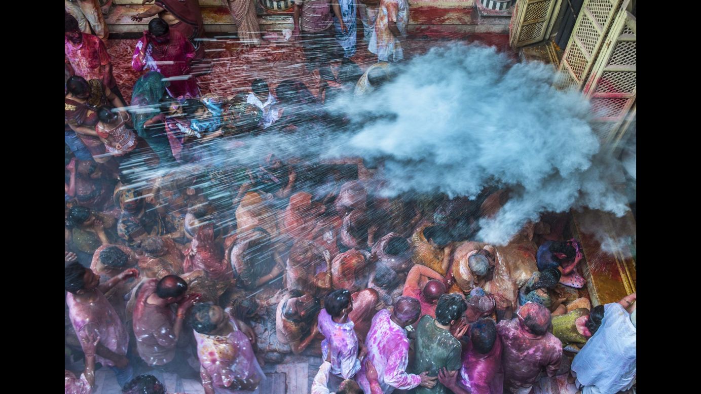 People throw colored powder on the crowds at a temple in Kolkata, India, on March 17.