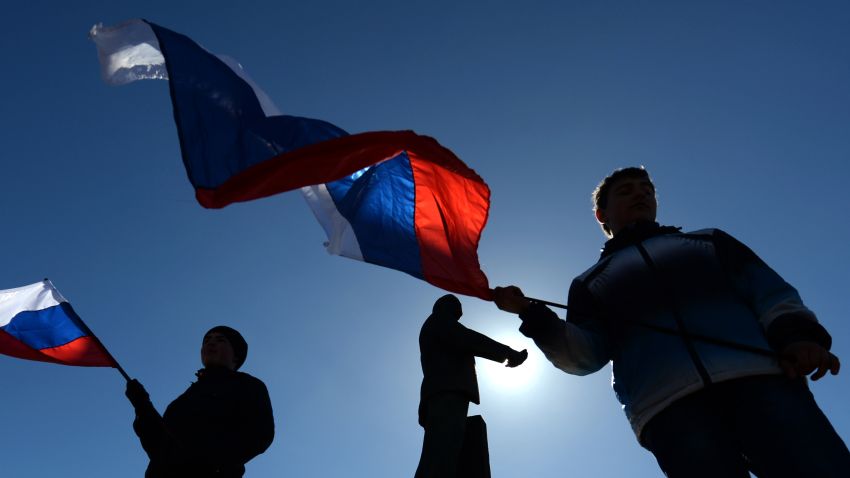 People wave Russian flags in Simferopol's Lenin Square on March 17, 2014.