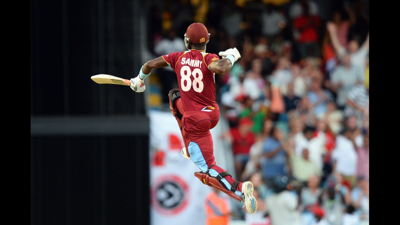 Darren Sammy, captain of the West Indies cricket team, leaps in the air after hitting the final runs to win the second T20 match against England on Tuesday, March 11, in Bridgetown, England.