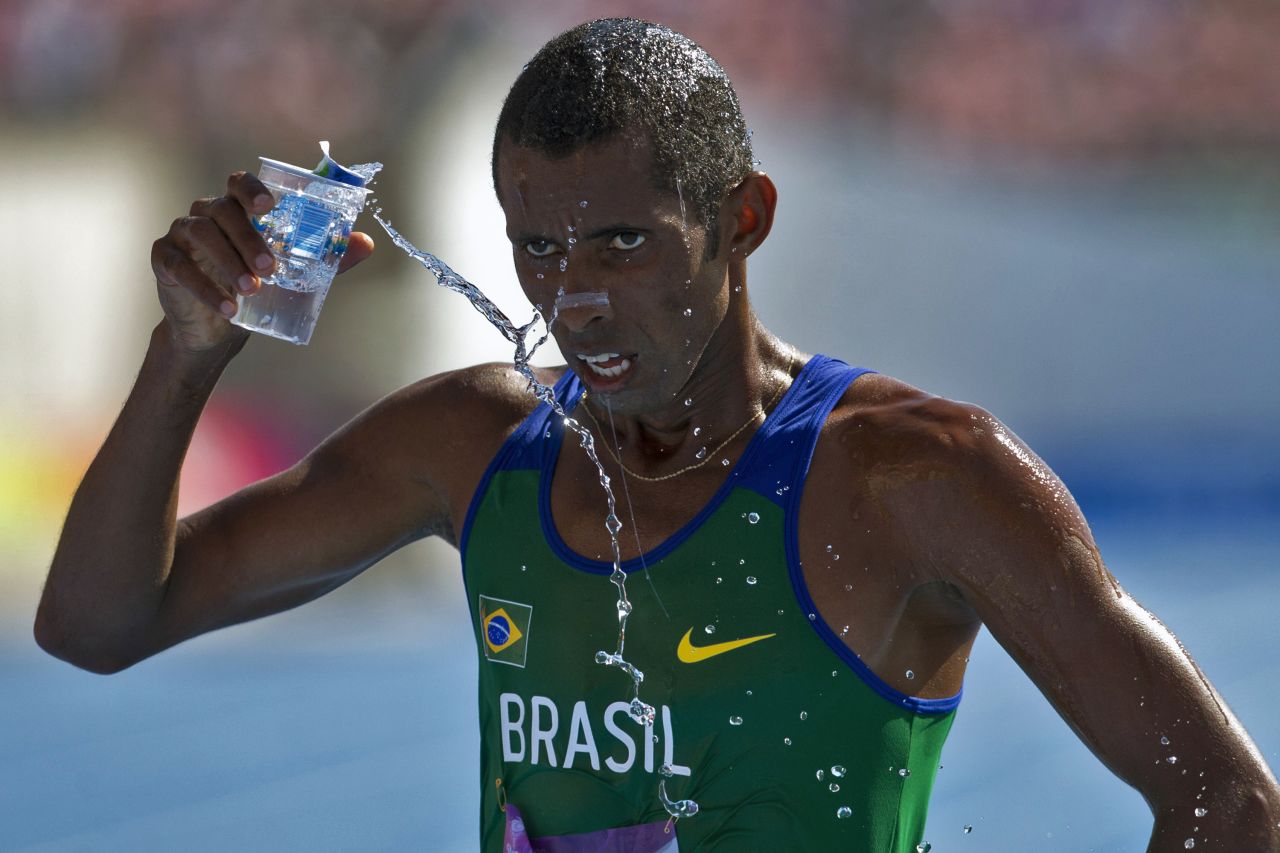 Giovani dos Santos refreshes himself Thursday, March 13, after crossing the finish line in the 10,000-meter race at the South American Games in Santiago, Chile.