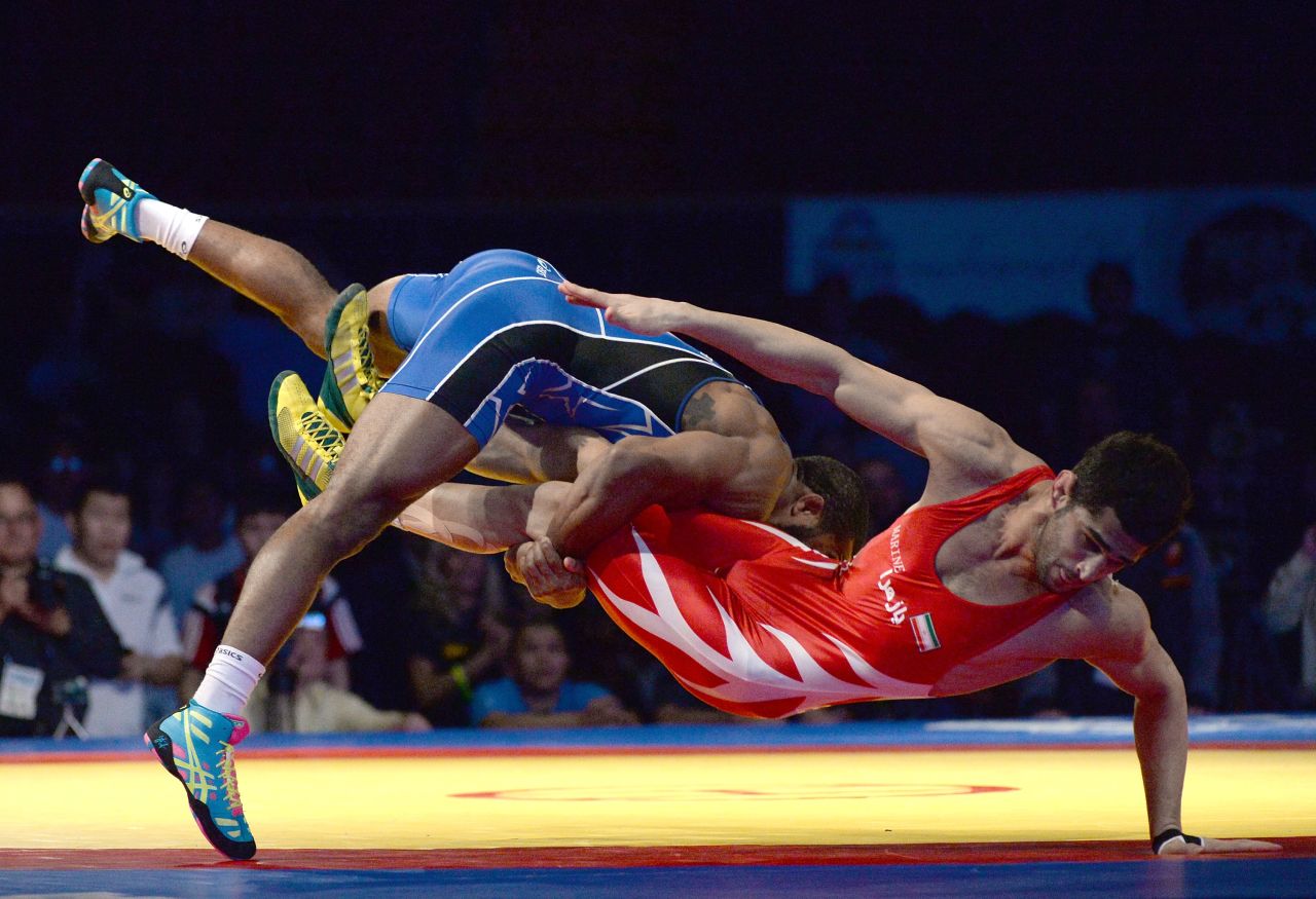 Jordan Burroughs of the United States, left, takes down Ezzatollah Akbari Zarinkolaei of Iran during the FILA Wrestling World Cup in Inglewood, California, on Saturday, March 15.