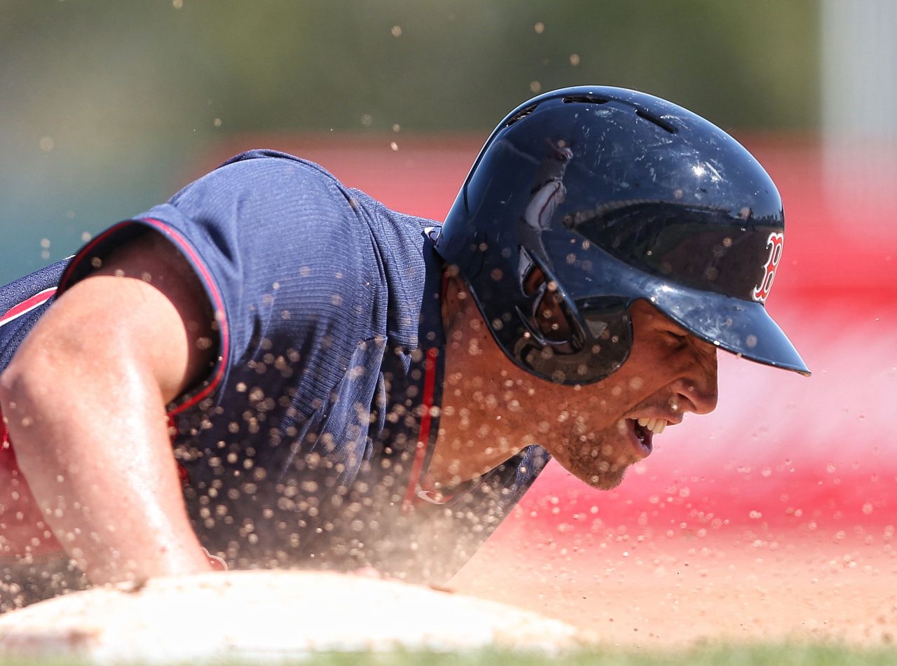 Garin Cecchini of the Boston Red Sox slides into first base during a spring training game against Baltimore on Tuesday, March 11, in Sarasota, Florida.