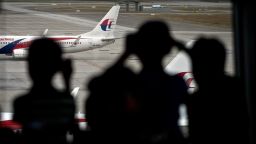 Malaysian children are silhouetted as they watch a Malaysia Airlines (MAS) plane taxi on the runway at Kuala Lumpur International Airport in Sepang on March 17, 2014.