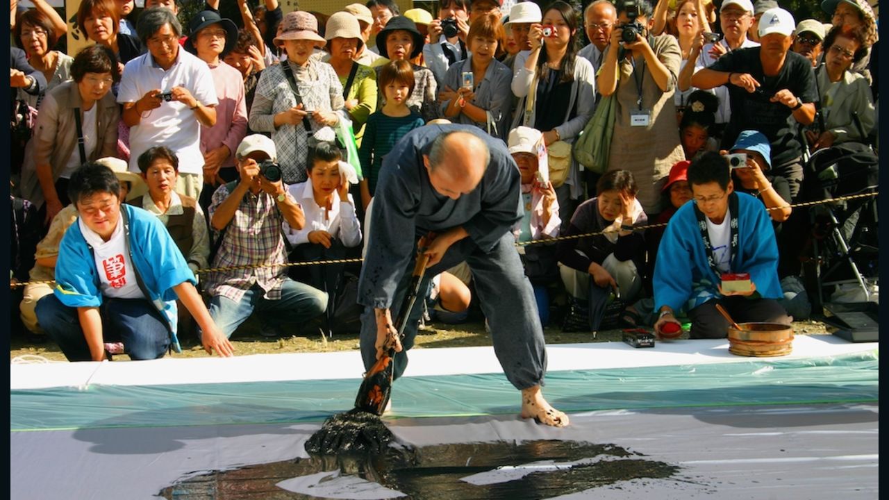 A calligraphy master uses a giant brush to put on a show at the annual Kumano Brush Festival. 