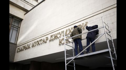 Nameplates on the front of the Crimean parliament building get removed Tuesday, March 18, in Simferopol.