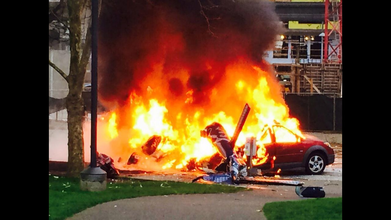A car burns at the scene of the crash outside the KOMO-TV studios.