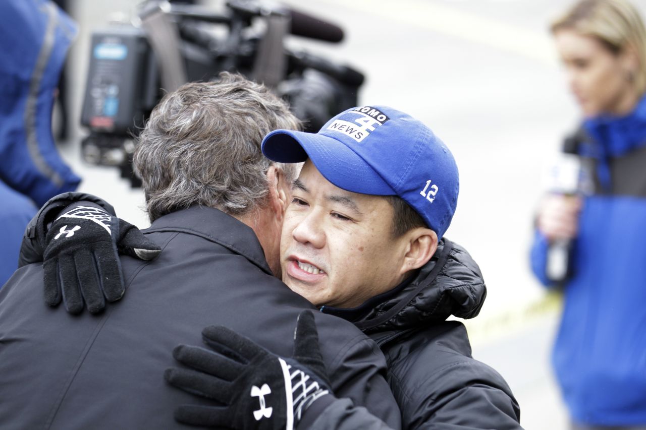 Norm Mah, assignment editor for CNN affiliate KOMO-TV, gets a hug as he works at the scene of the crash. The crash happened near the KOMO-TV studios, and the helicopter was used by both KOMO and KING, according to KING's website.