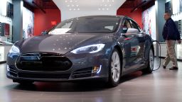 A Tesla Motors Inc. Model S connected to a charger sits on display at the company's store at the Short Hills Mall in Short Hills, New Jersey, U.S., on Wednesday, March 12, 2014. Governor Chris Christies administration blocked Tesla Motors Inc., the electric-car maker that doesnt have franchised retail dealers, from direct auto sales in a move the company said could shutter its only two stores in New Jersey. Photographer: Emile Wamsteker/Bloomberg via Getty Images