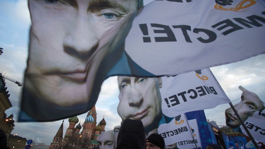 People rally in support of Crimea joining Russia, with banners and portraits of Russian President Vladimir Putin, reading "We are together," in Red Square in Moscow, Tuesday, March 18, 2014.